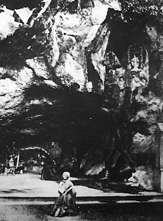 Bernadette bidt aan de grot